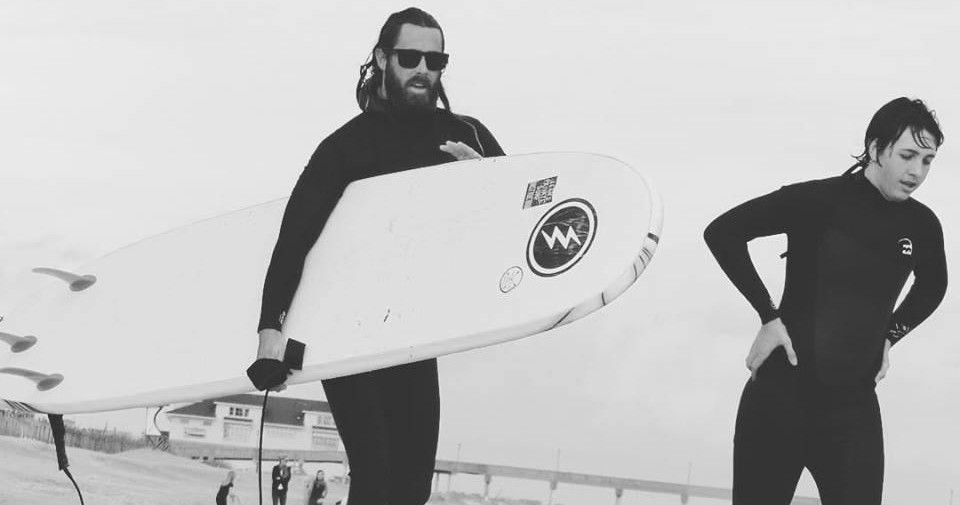 1-Hr Private Lesson with Sean Image 1 Guys in wetsuits surfing